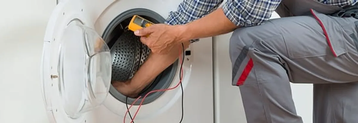 Dryer repair technician inspecting and repairing a clothes dryer in Nashua, NH
