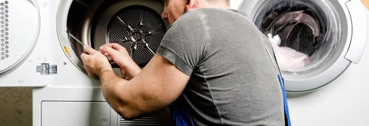 Dryer repair technician fixing a clothes dryer drum in Nashua, NH