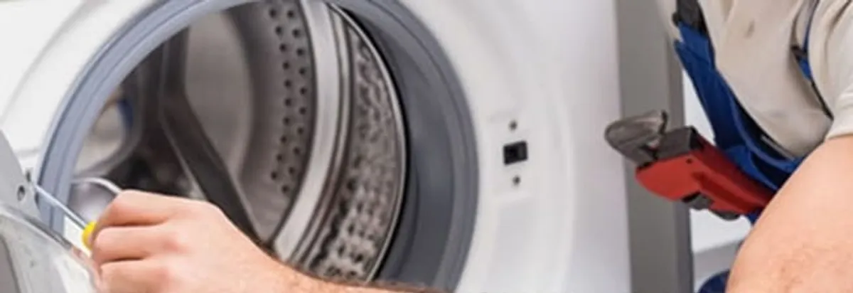 Appliance technician repairing a clothes dryer drum and internal parts in Nashua, NH